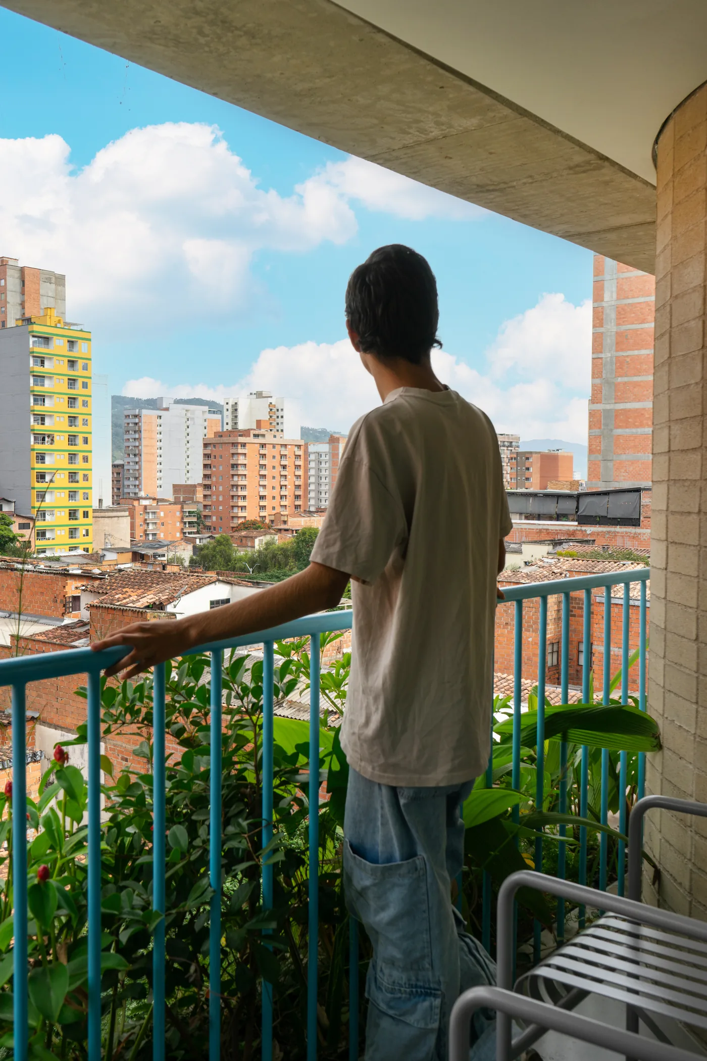 Balcón con baranda turquesa y vista a la ciudad