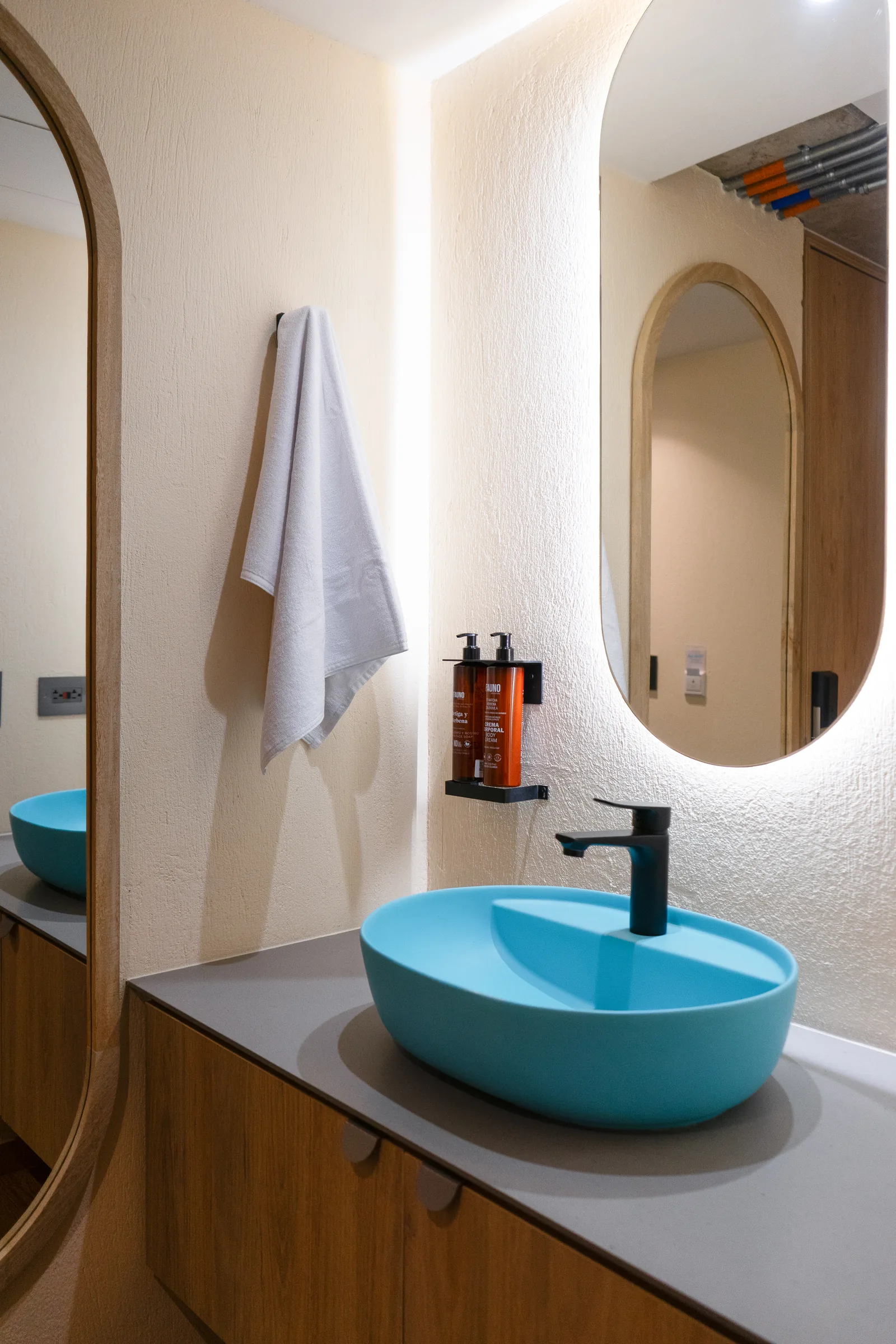 Baño de diseño con lavamanos turquesa en Hotel Once22